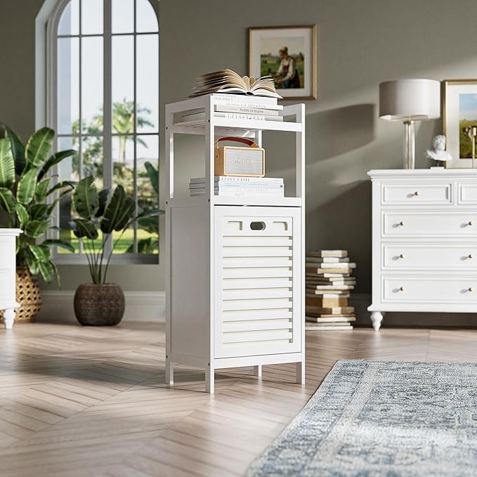 White storage cabinet with books in a room with a dresser, lamp, and plants.